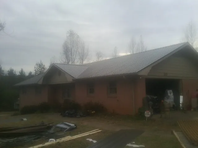 Gray metal roof on a stucco house with an attached garage in Lancaster